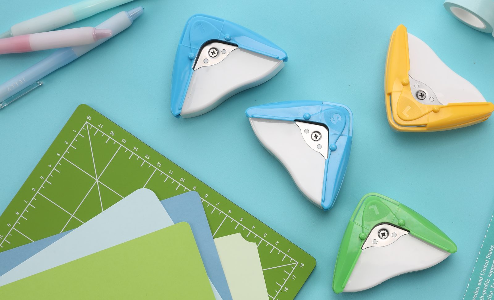 aidox corner rounders in blue, yellow and green on a cutting mat